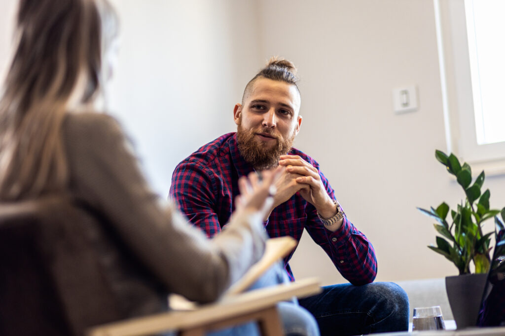 A photograph of a man talking to a female psychologist about mental health.