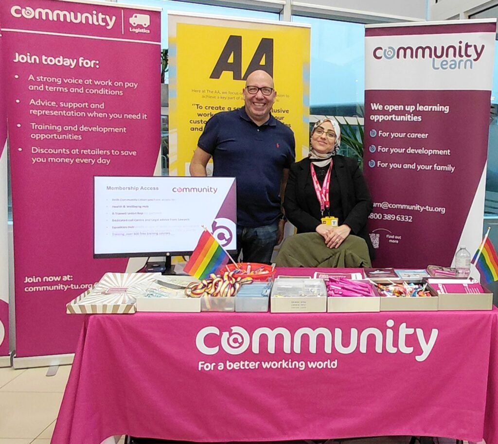 A photograph of Sean Mallenby and Hiba Bayoumi, stood at a Community Union stand at AA Newcastle.